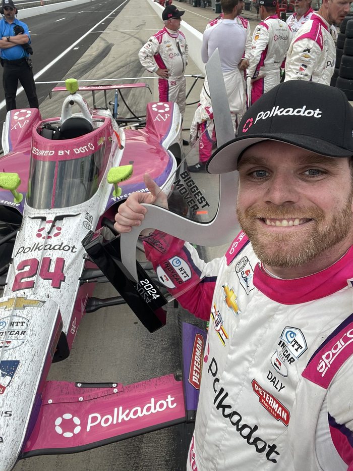 Conor Daly with the biggest mover award beside the Polkadot car
